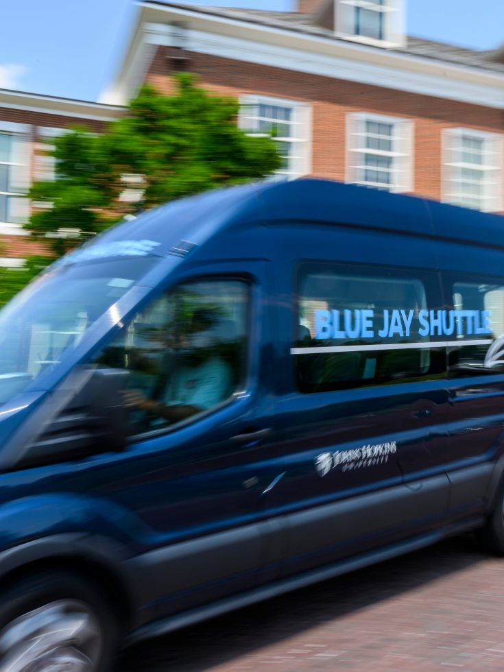 The JHU Blue Jay Shuttle in front of Mason Hall.